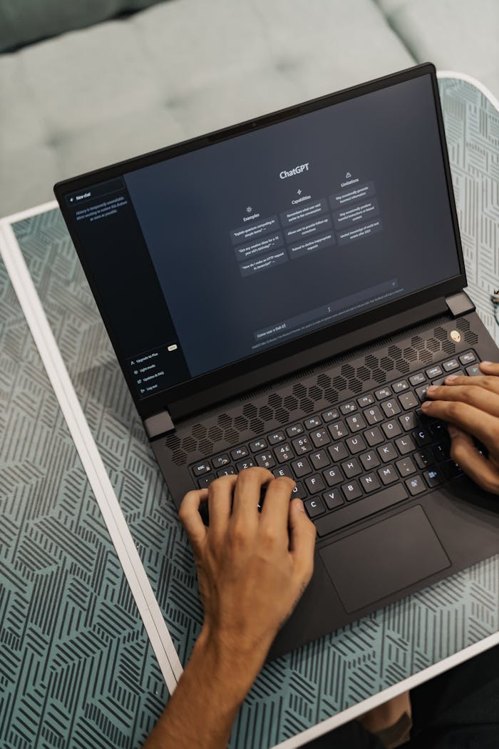 about-us Person typing on a laptop with ChatGPT displayed, showcasing modern technology use.